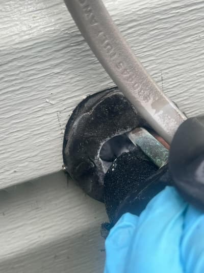 Close-up of a nest being removed from the underside of a roof overhang